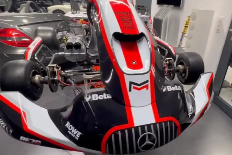 Schwarzer, weißer und roter Renn-Kart mit einem Mercedes-Benz-Logo auf dem Frontgrill.